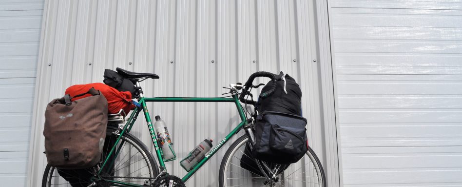 Chris Lee's bike loaded with supplies and leaning against a wall, ready for his cross-Canada journey.