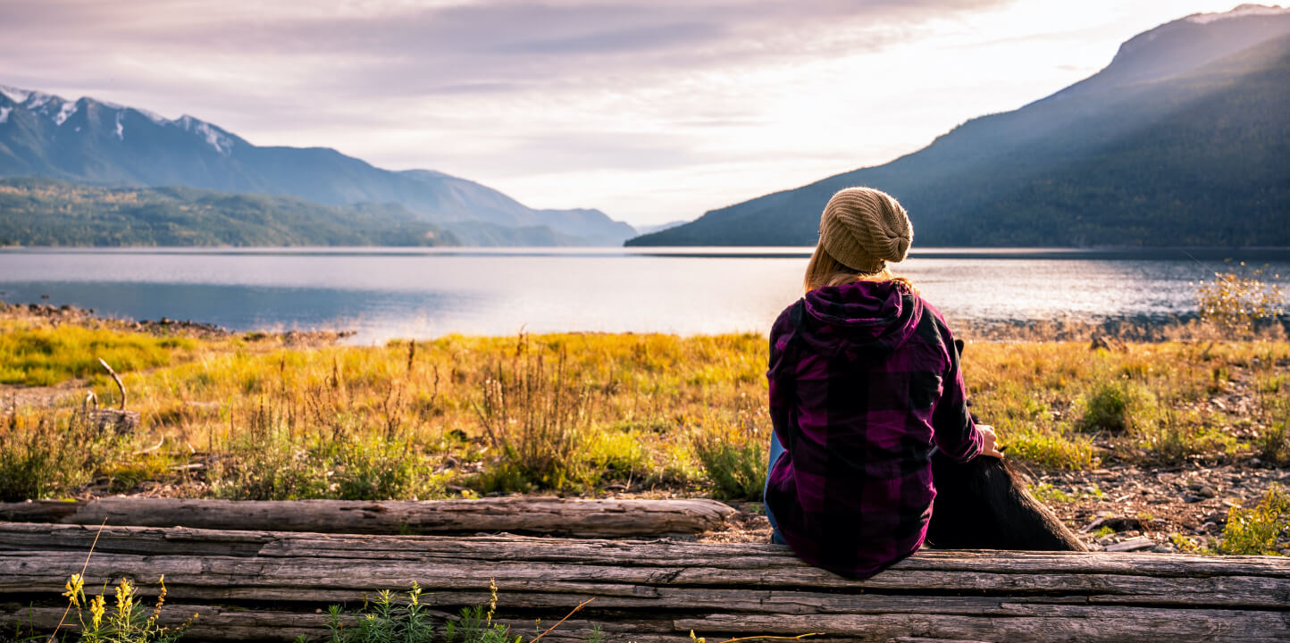 Woman looking at lake with mountains in the background