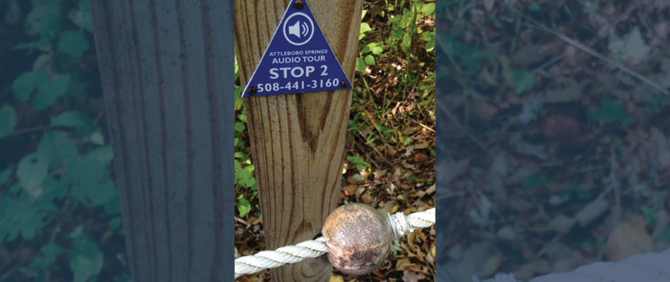 A bead along a guide rope in front of a wooden pole with an audio stop sign on the pole.