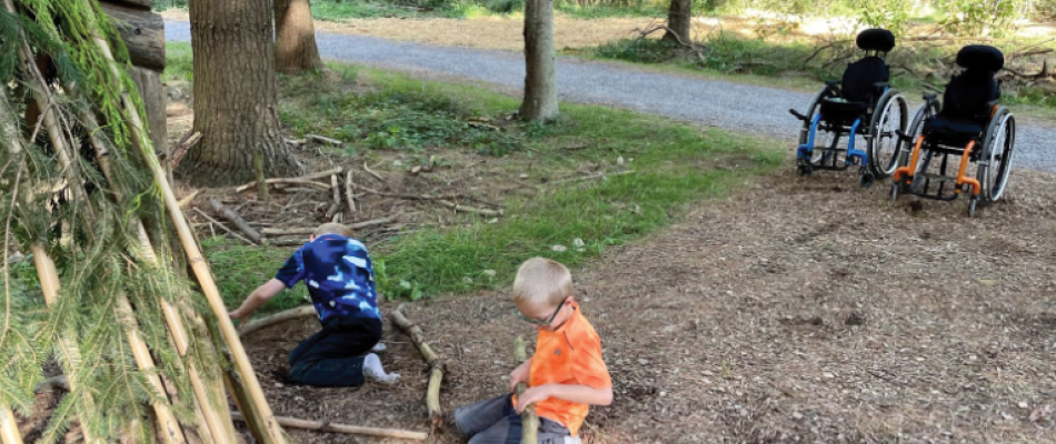 Two children playing on the ground at the Design Zone at the Autism Nature Trail at Letchworth State Park, New York.