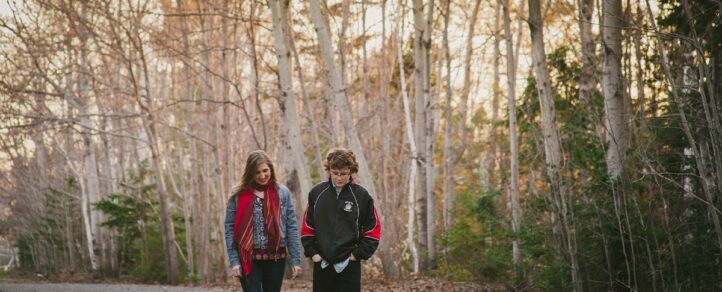 Leave No Trace Principles: To young adults walking along a gravel path, surrounded by trees.