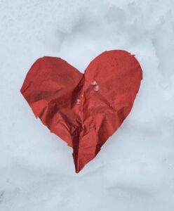 Red heart on the snow-covered trail