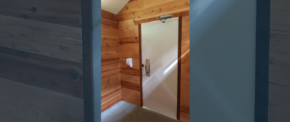 The interior of an accessible outhouse with a lever handle