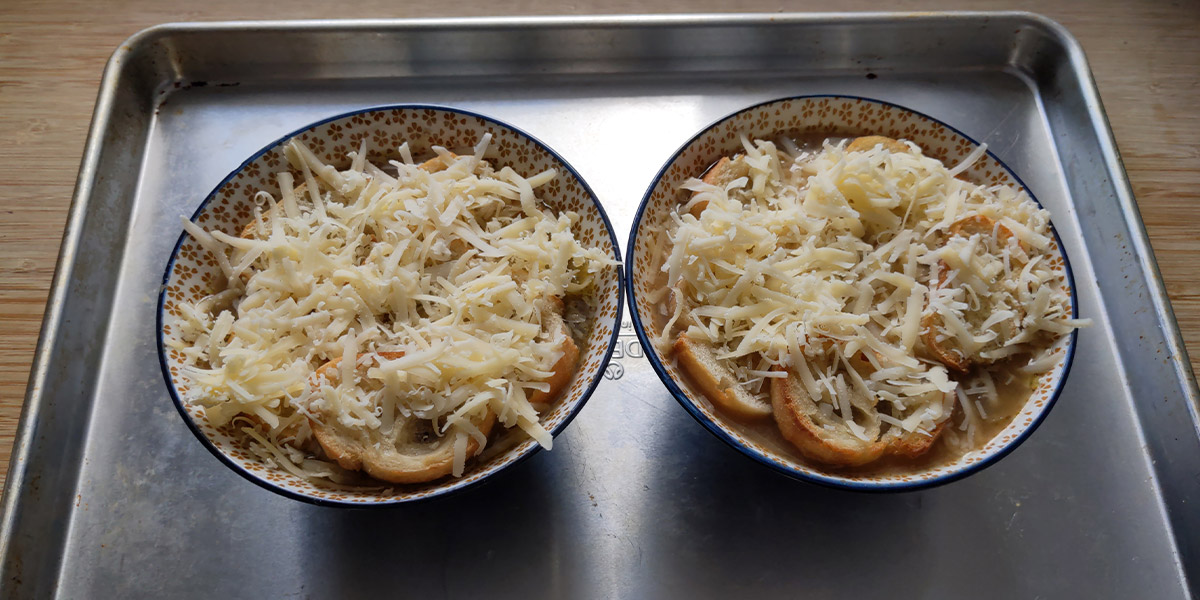 Food series: Crockpot Recipes - two bowls of food with melted cheese. Both bowls are placed on a metal baking pan.