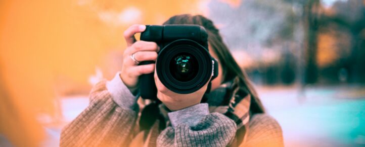 An image of someone holding a professional camera to their face