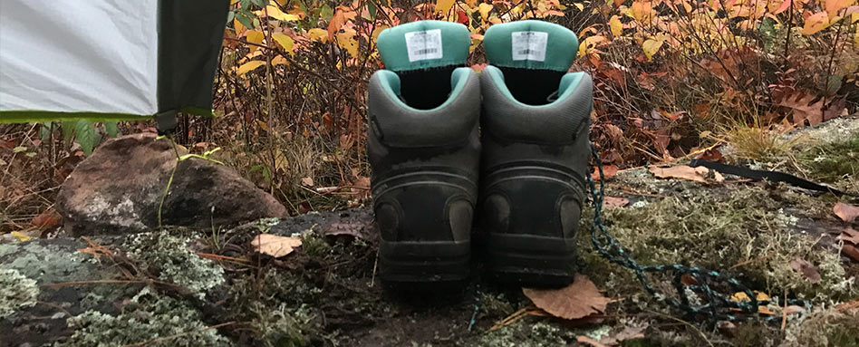 Hiking boots on a trail, surrounded by leaves
