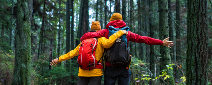 Two hikers on the trail with their arms wrapped around each other