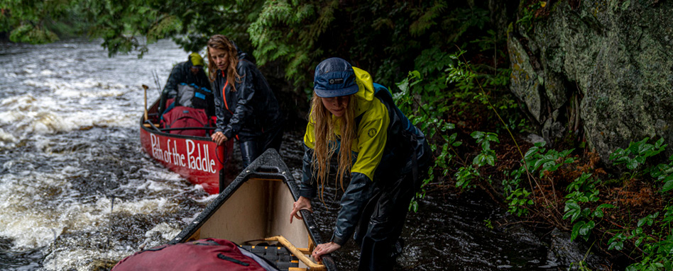 Two adults guiding canoes down Maukinak Water Trail path