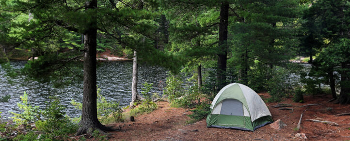 A tent out in the woods by water