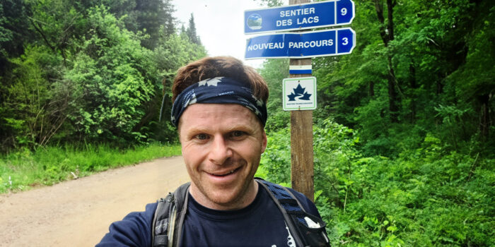 Tony Pringle standing in front of a Trans Canada Trail sign on the trail