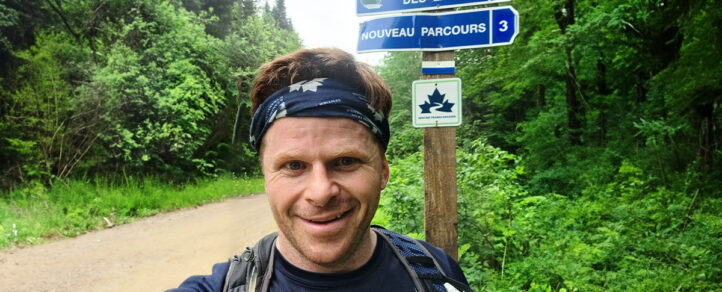 Tony Pringle standing in front of a Trans Canada Trail sign on the trail