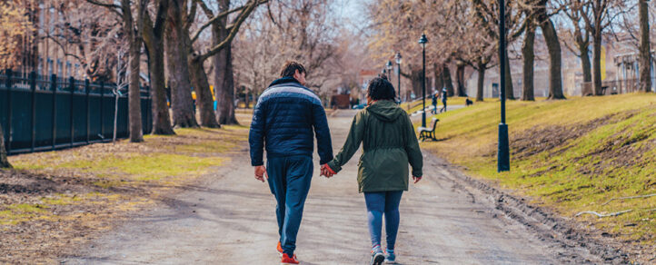 Two adults holding hands walking