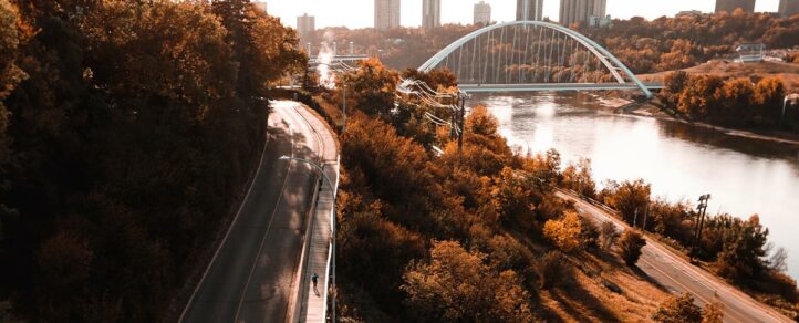 The cover photo of Trans Canada Trail's imapct report. It shows a person running a boardwalk along the North Saskatchewan River in Edmonton, Alberta