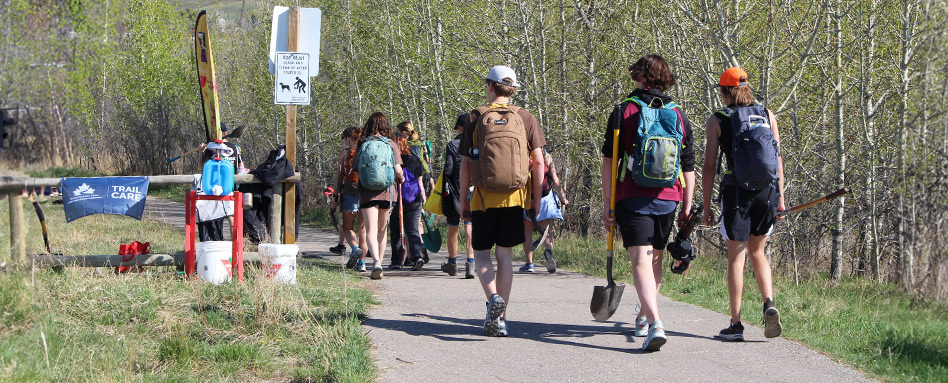 Volunteers walking along the trail and the Town of Cochrance, Alberta Trail Care Event