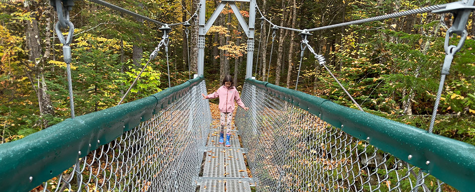Un enfant debout sur un pont du sentier Louise-Gasnier