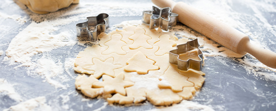 Cookie dough and cookie cutters to make holiday cookies