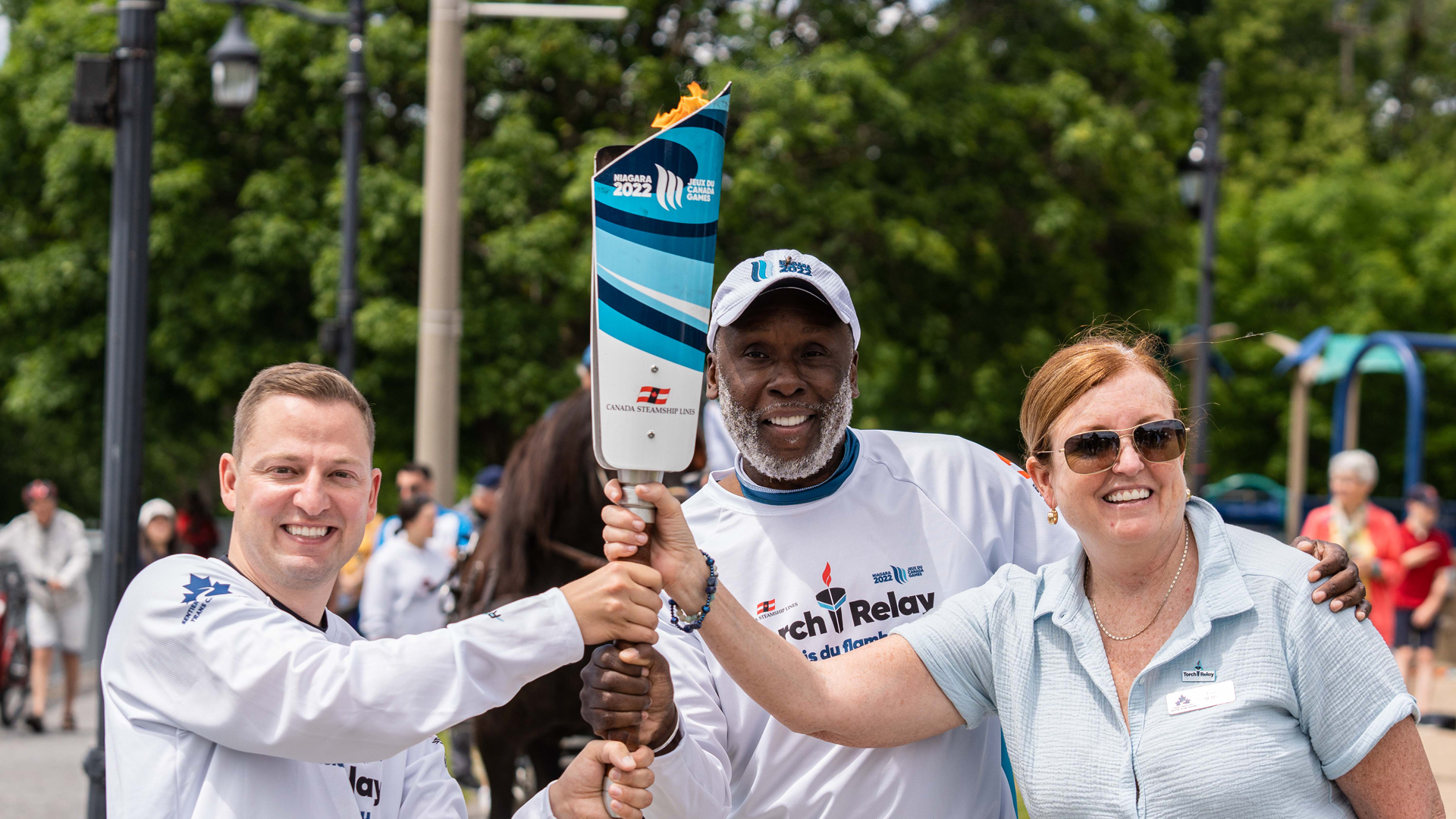 Eleanor McMahon, Bruny Surin, and Mathieu Traversy holding the torch at the Niagara 2022 Canada Summer Games Torch Relay
