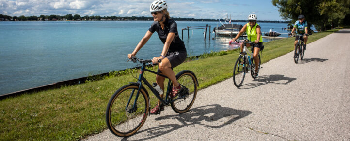 Two adult women riding their bikes along the Windsor Waterfront Trail