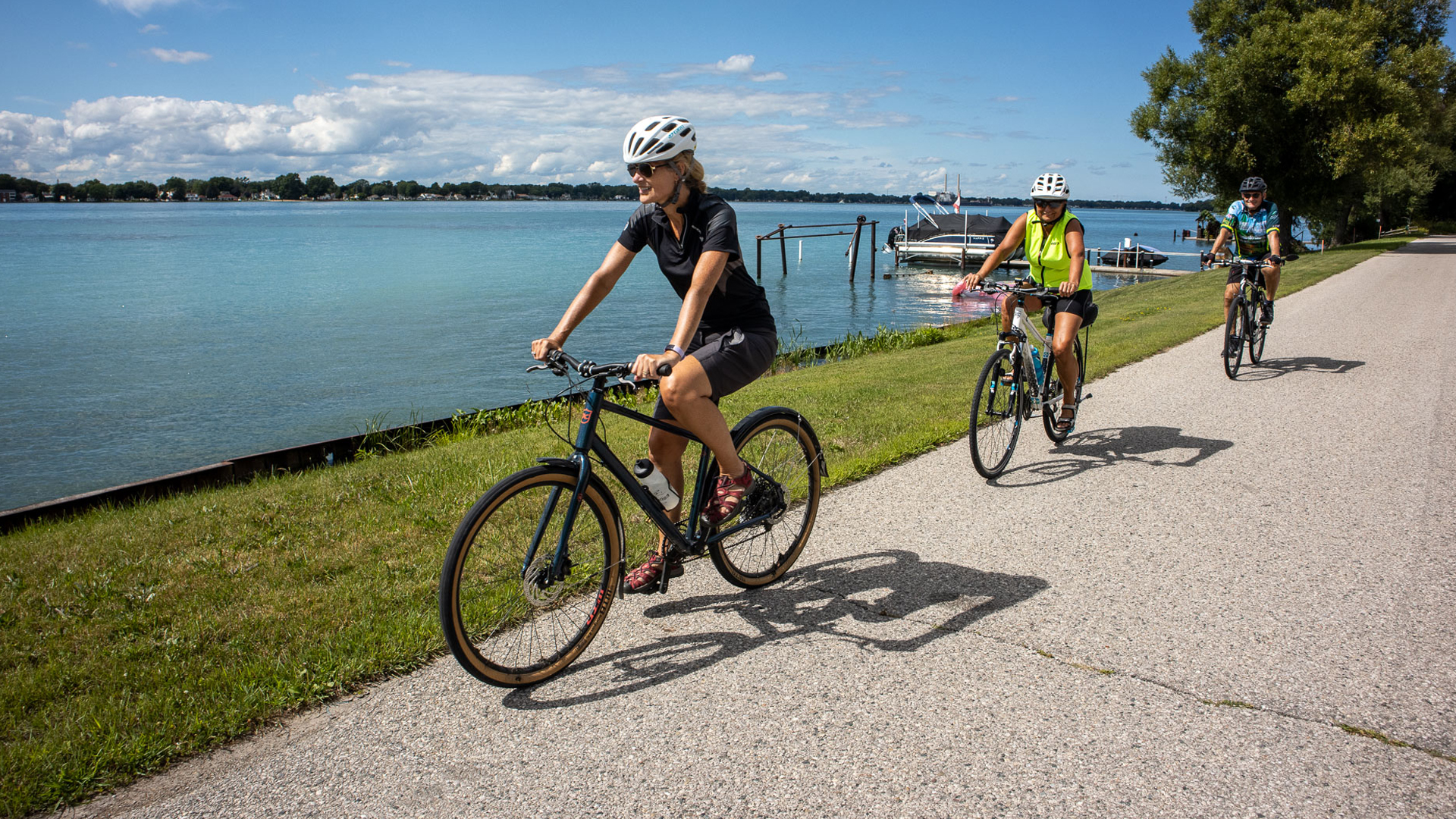Two adult women riding their bikes along the Windsor Waterfront Trail