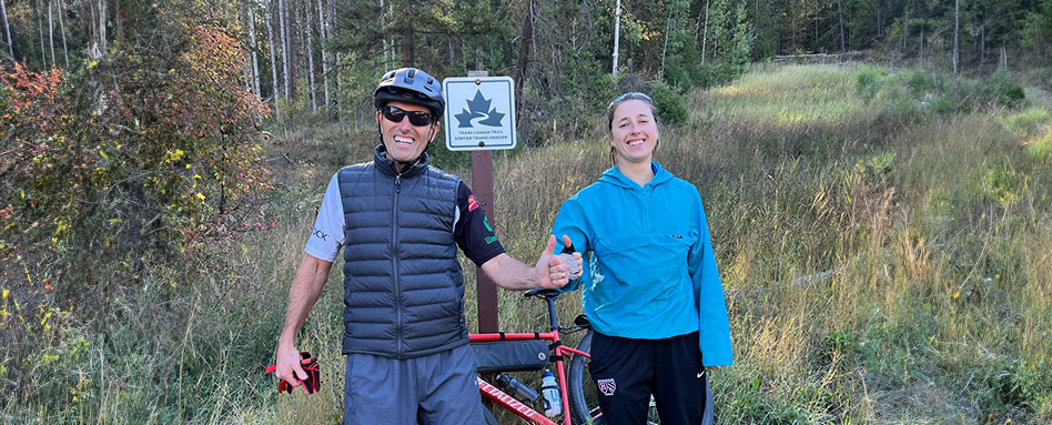 John and Meimei Weston standing in front of a Trans Canada Trail sign