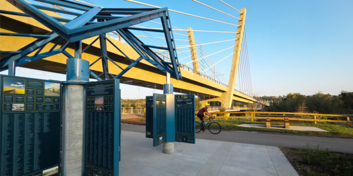 A man riding a bike under a bridge. | Un homme faisant du vélo sous un pont.