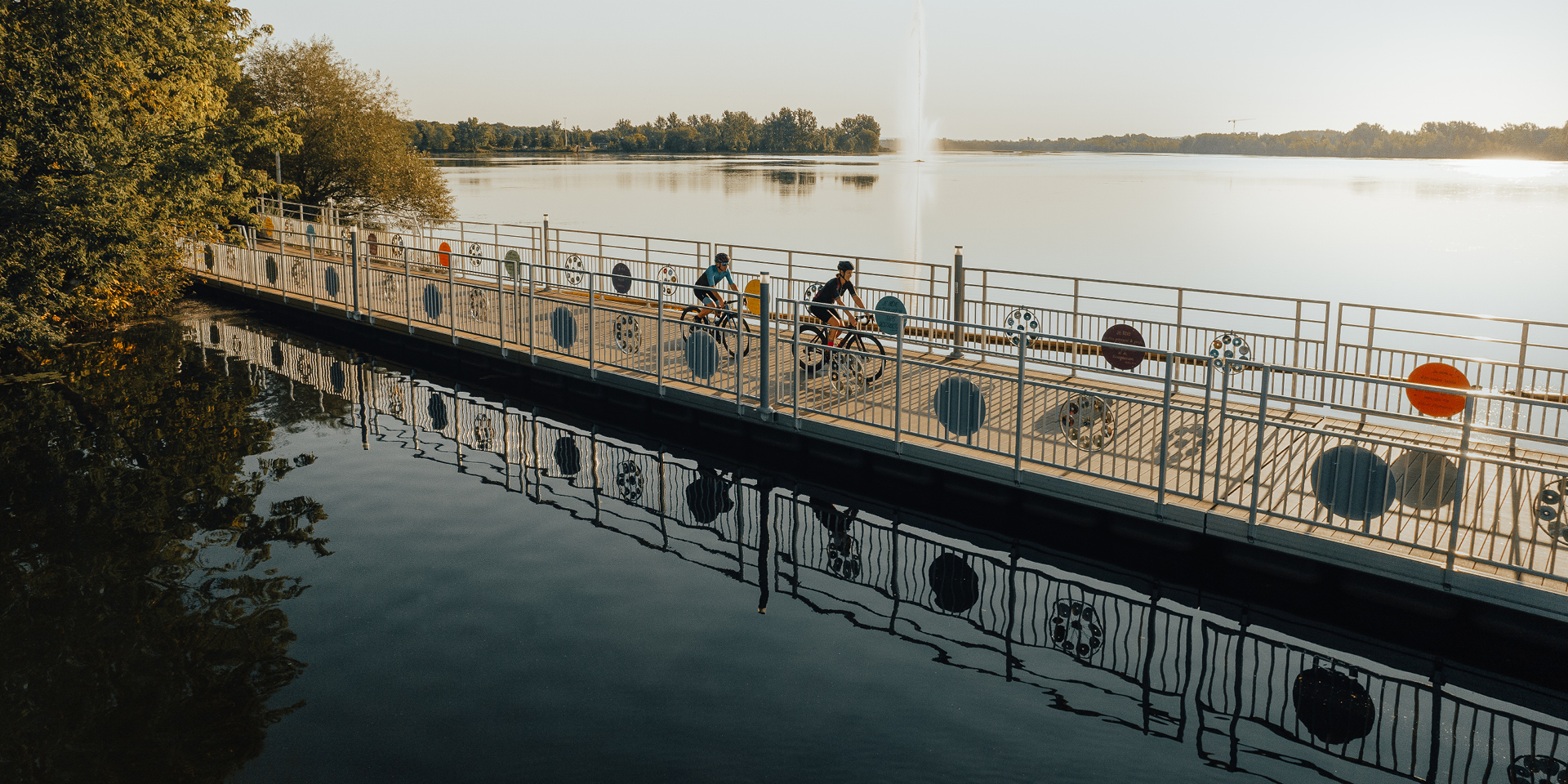 Two cyclists riding along a Granby bridge