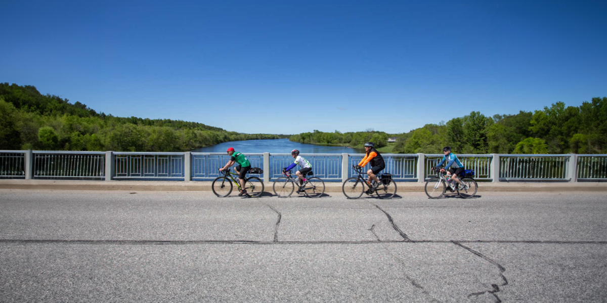 Four cyclists riding on a bridge for the Great Waterfront Trail Adventure