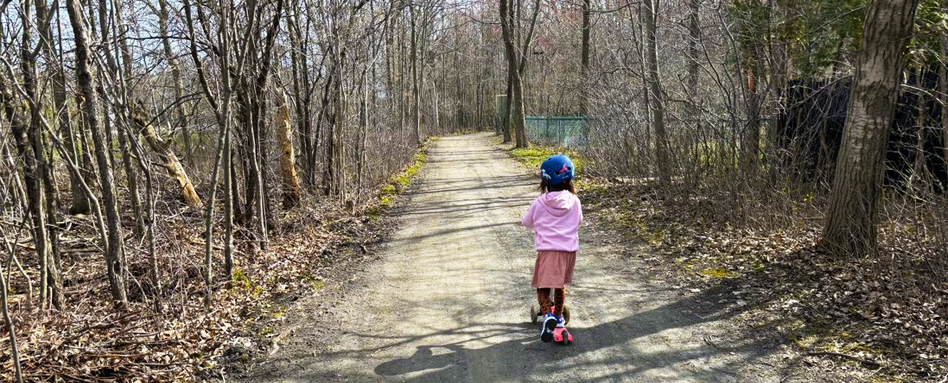 Ellie riding her scooter on the Ville de Longueuil Trail 