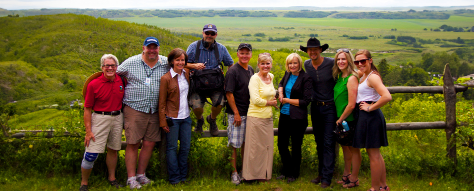 Laureen Harper and her team, posing for a photo on a picturesque hillside. | Laureen Harper et son équipe, posant pour une photo sur une colline pittoresque.