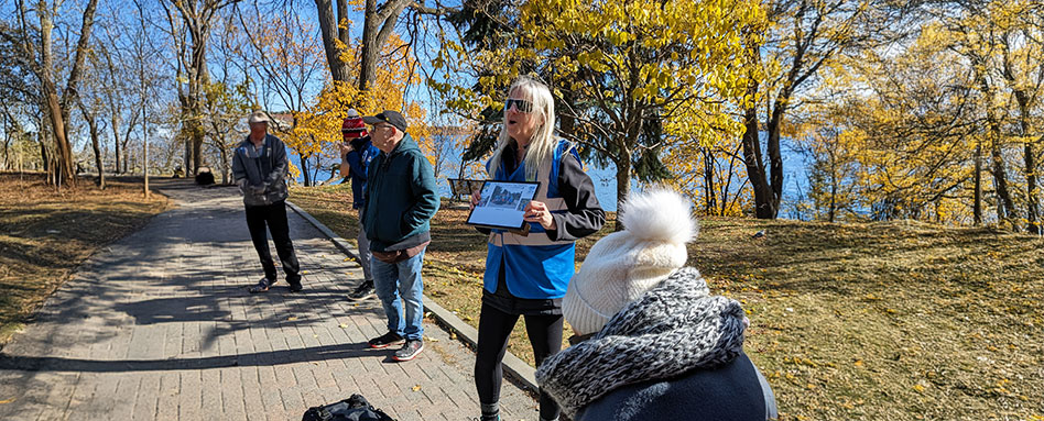 A diverse group of individuals stands on a path, participating in the Inclusive Hiking Program by Rainbow Routes. Un groupe diversifié de personnes se tient sur un sentier, participant au programme de randonnée inclusive de Rainbow Routes.