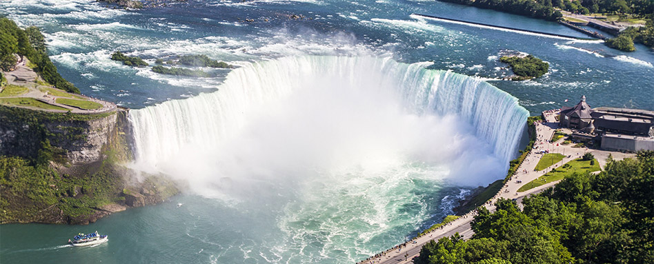 Aerial view of Niagara Falls in Canada, capturing the stunning waterfalls and the beautiful natural scenery surrounding them. Vue aérienne des chutes du Niagara au Canada, capturant les superbes chutes d'eau et le magnifique paysage naturel qui les entoure.