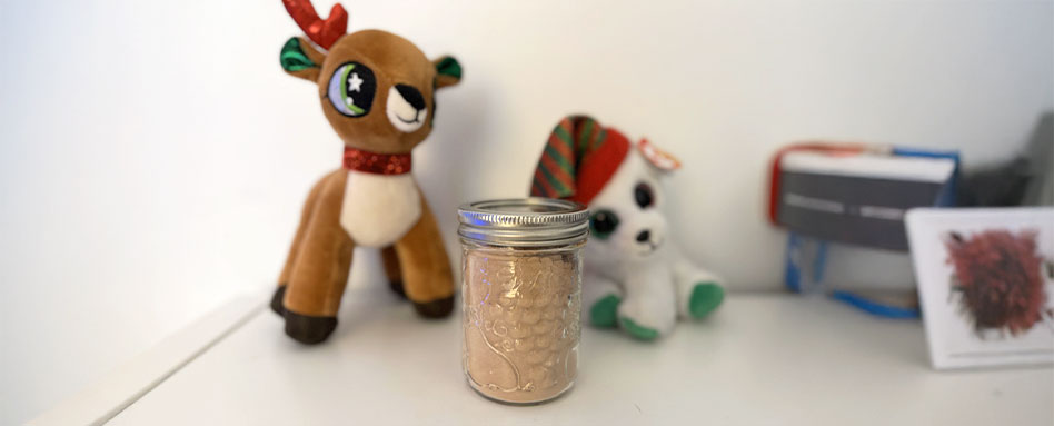 A jar filled with brown sugar next to a plush toy, representing a warm atmosphere for enjoying cranberry-almond overnight oats.