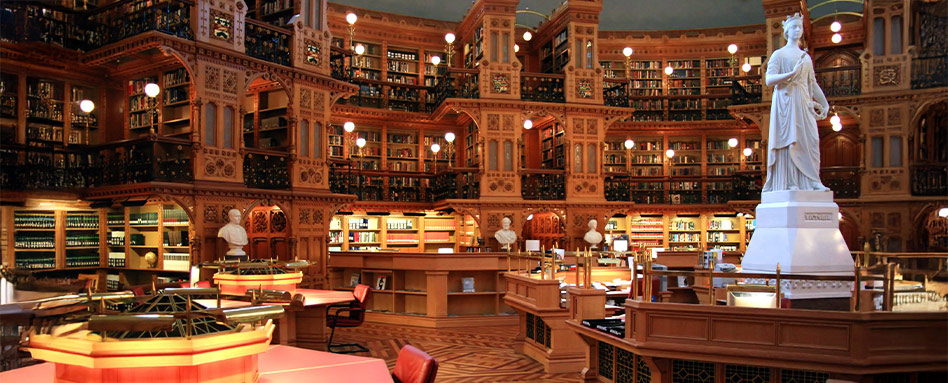 A library interior featuring numerous bookshelves and a prominent statue. L’intérieur d’une bibliothèque avec de nombreuses étagères remplies de livres et une statue imposante. 