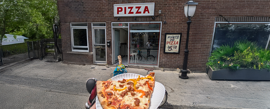 picture of someone holding a slice of pizza infront of a sign that reads: "pizza"