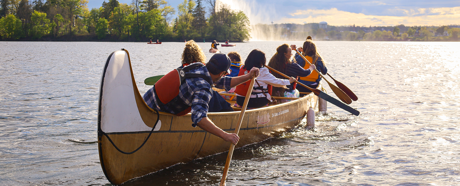 people paddling in a canoe on a lake on a sunny day