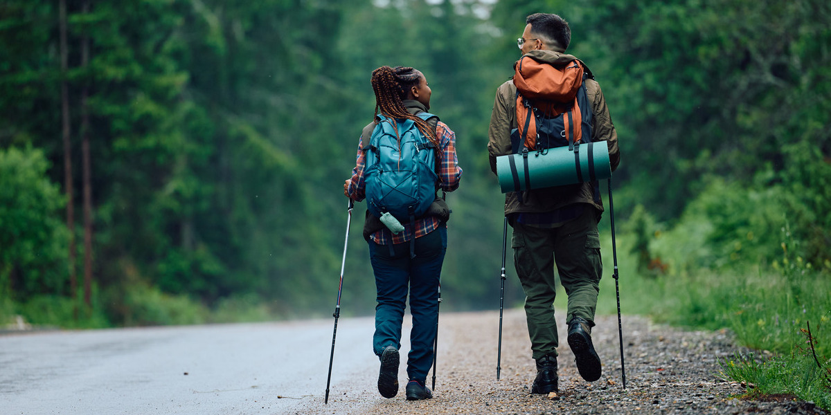 rearview of backpackers walking on trail