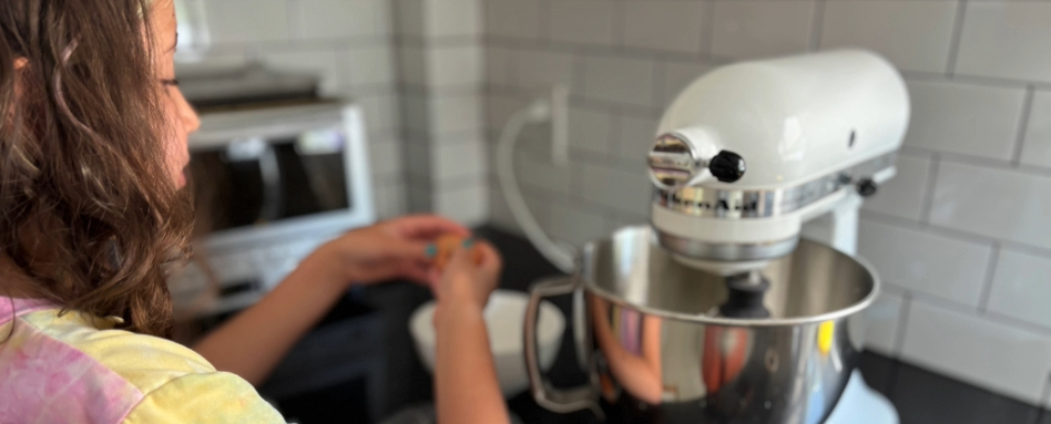 child putting egg in a mixer