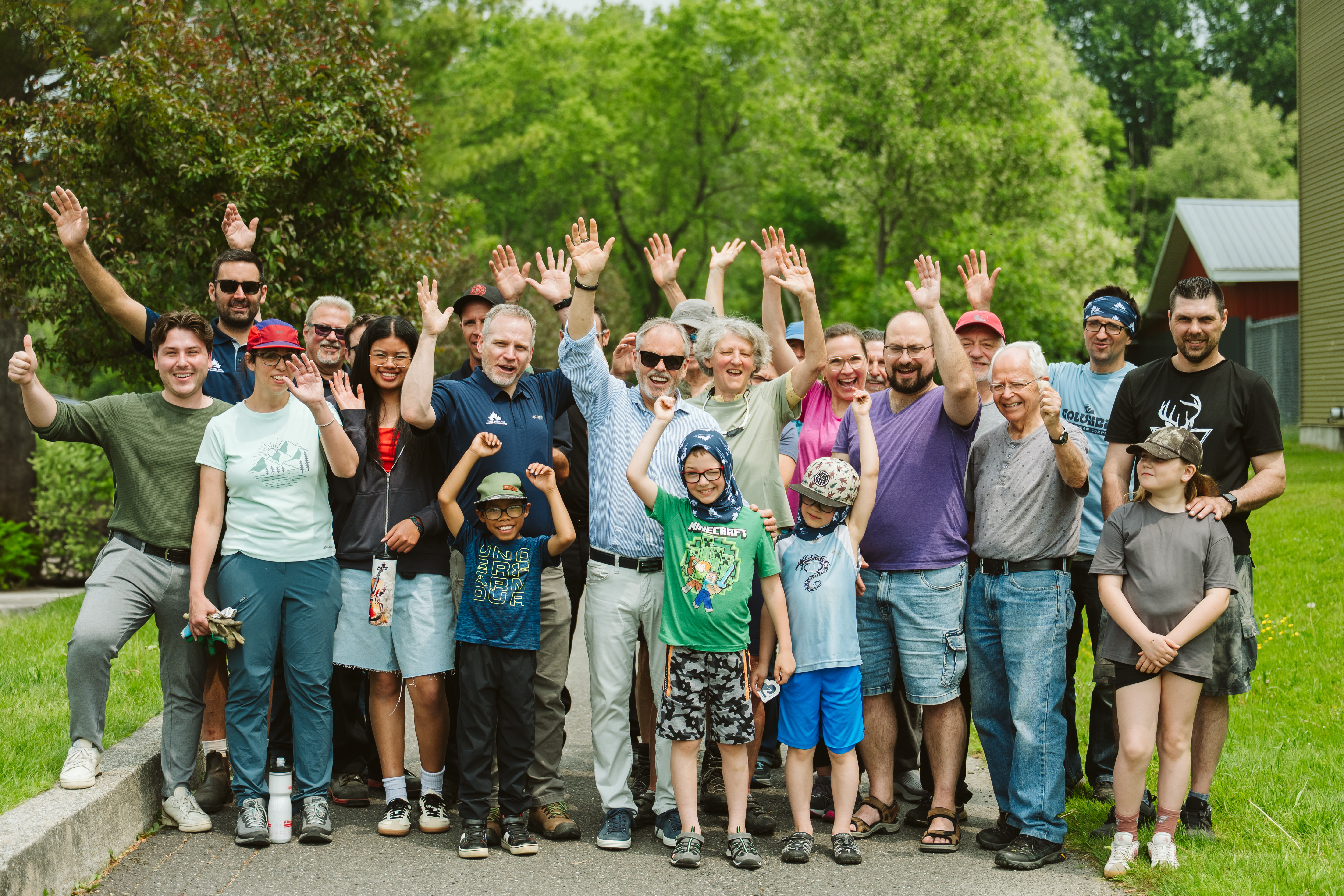 group of people smiling with arms in the air