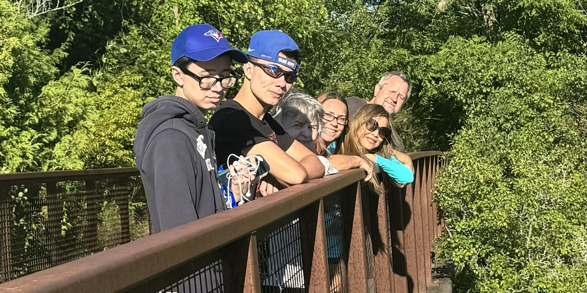 people stnading on a bridge posing for photo