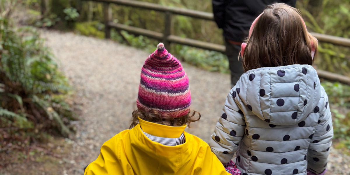 two children in winter clothing on a walking path