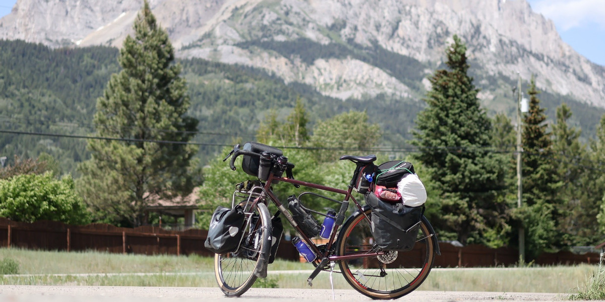 bike with camping gear infront of mountain and trees