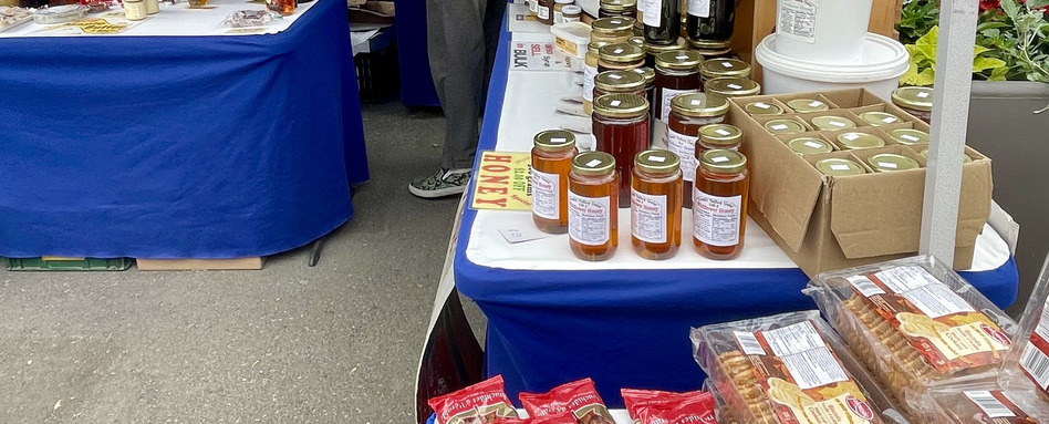 photo of honey and snacks at a farmers market table