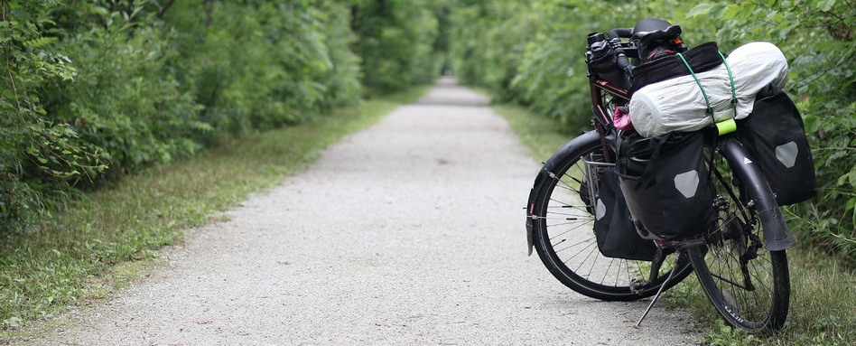 bike on a path with camping gear and trees in background