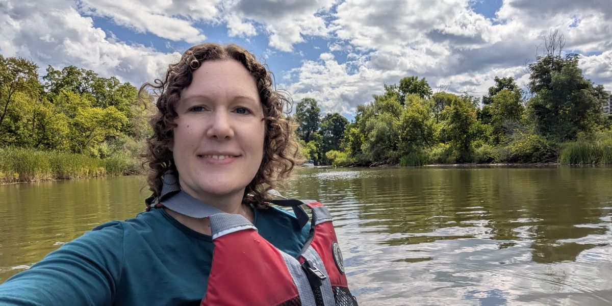woman smiling taking a selfie infront of a lake