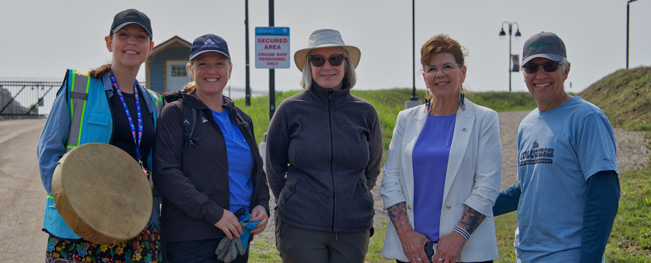 people posing for a photo infront of a trail sign