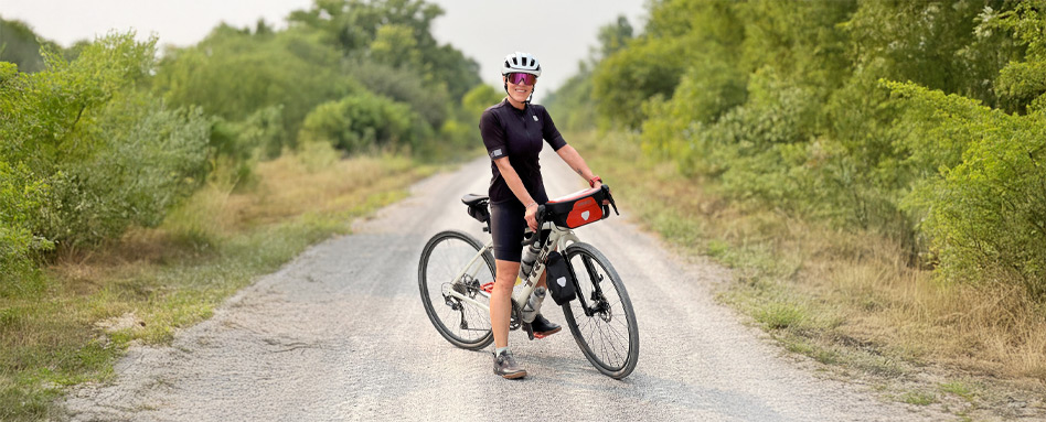 woman on a bike on a trail posing and smiling in biking gear