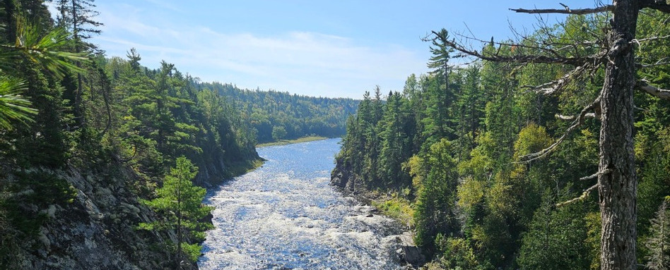 03NB_trail-profile_sentier-nepisiguit-migmaq-trail_snmt-association_the-narrows_Web_StorySupport_Images_948x383 | Trans Canada Trail birdseye of rapids in a river surrounded by forest on a sunny day