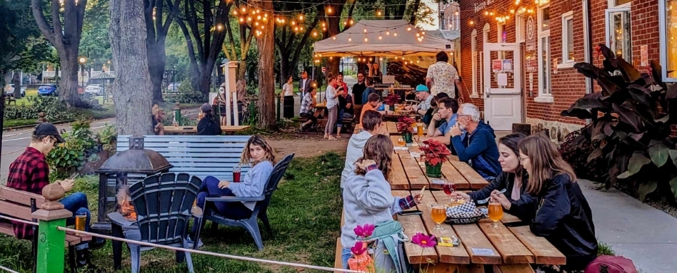 people sitting on patio enjoying dinner under stringlights