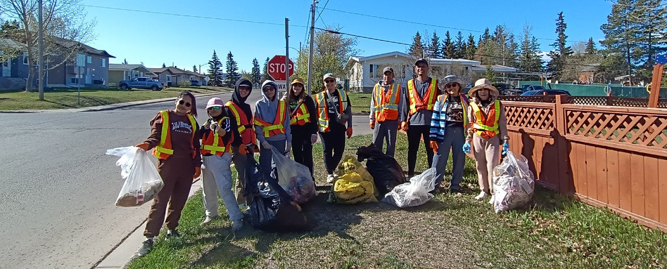 people in hazard vests posing with trash bags in field on a sunny day