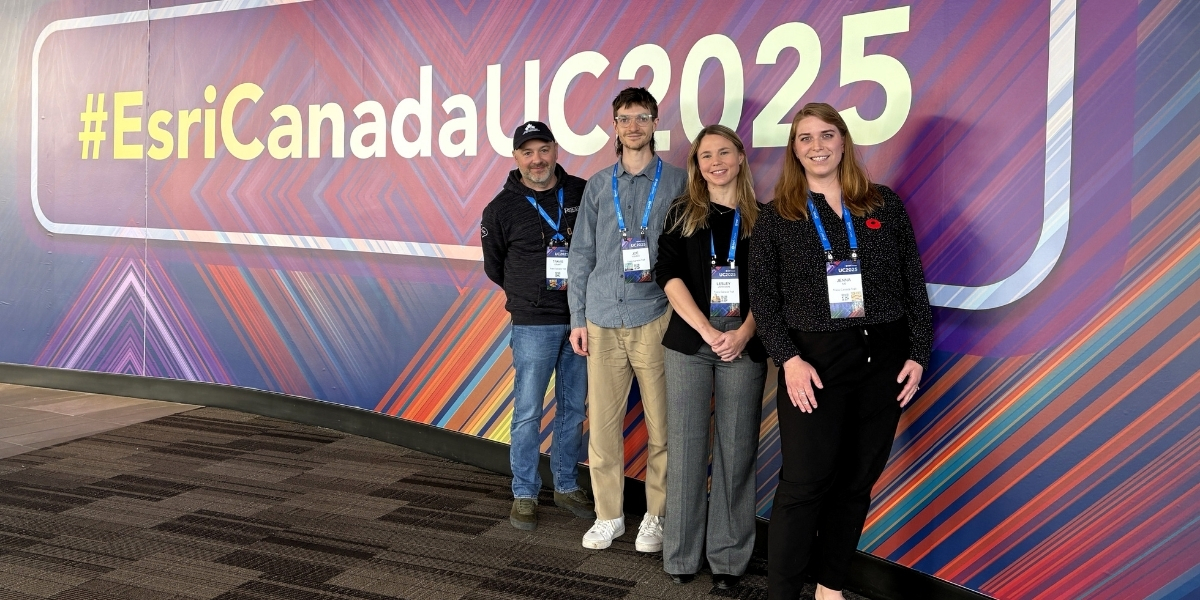 00Feature image_GIS Day team profile | Trans Canada Trail group of people standing infront of a buildboard smiling